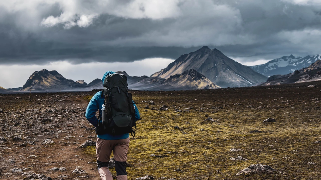 Solo hiker walking alone along a remote mountain trail
